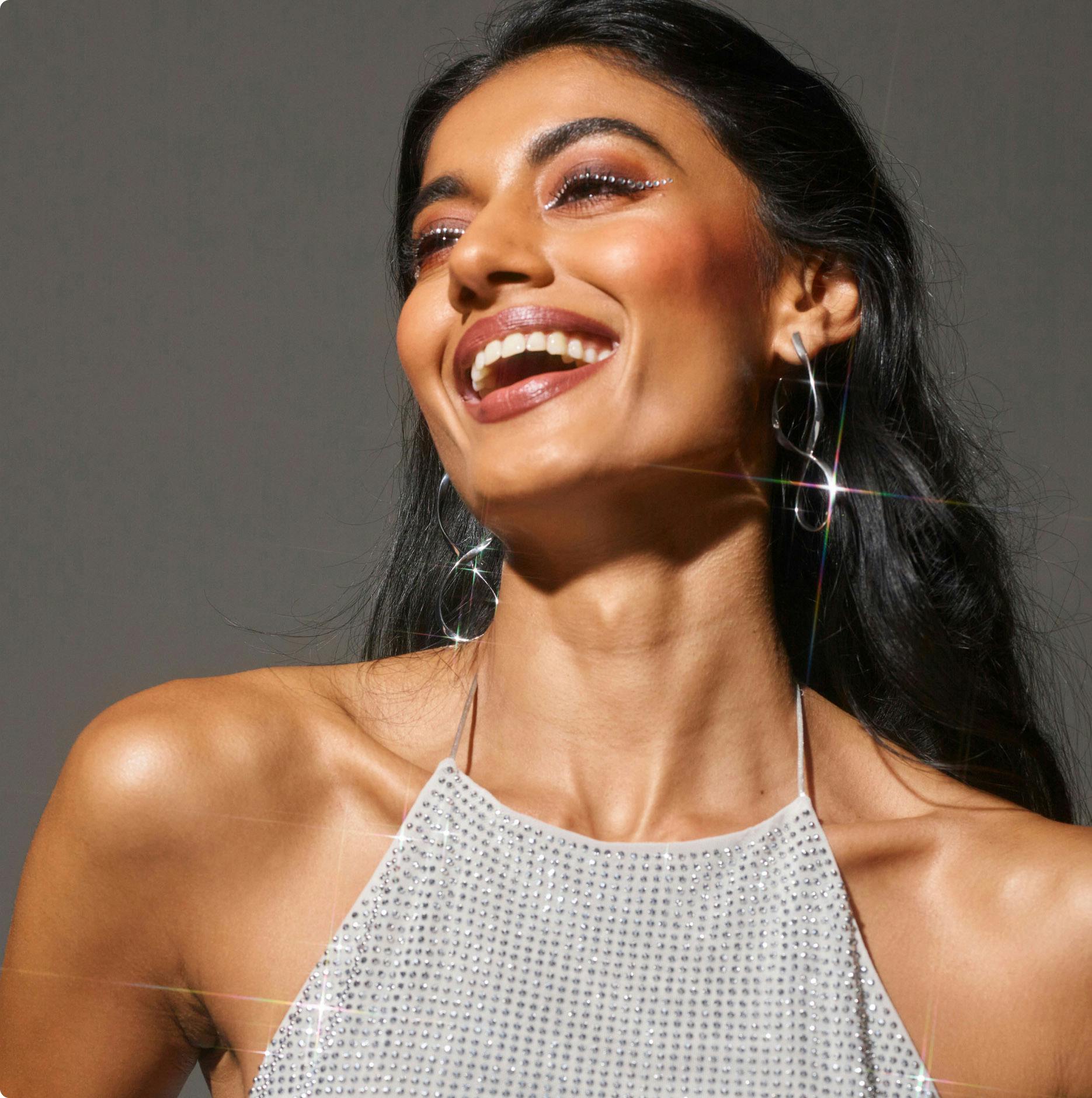 woman in a sparkly shirt with crystals on her eyes