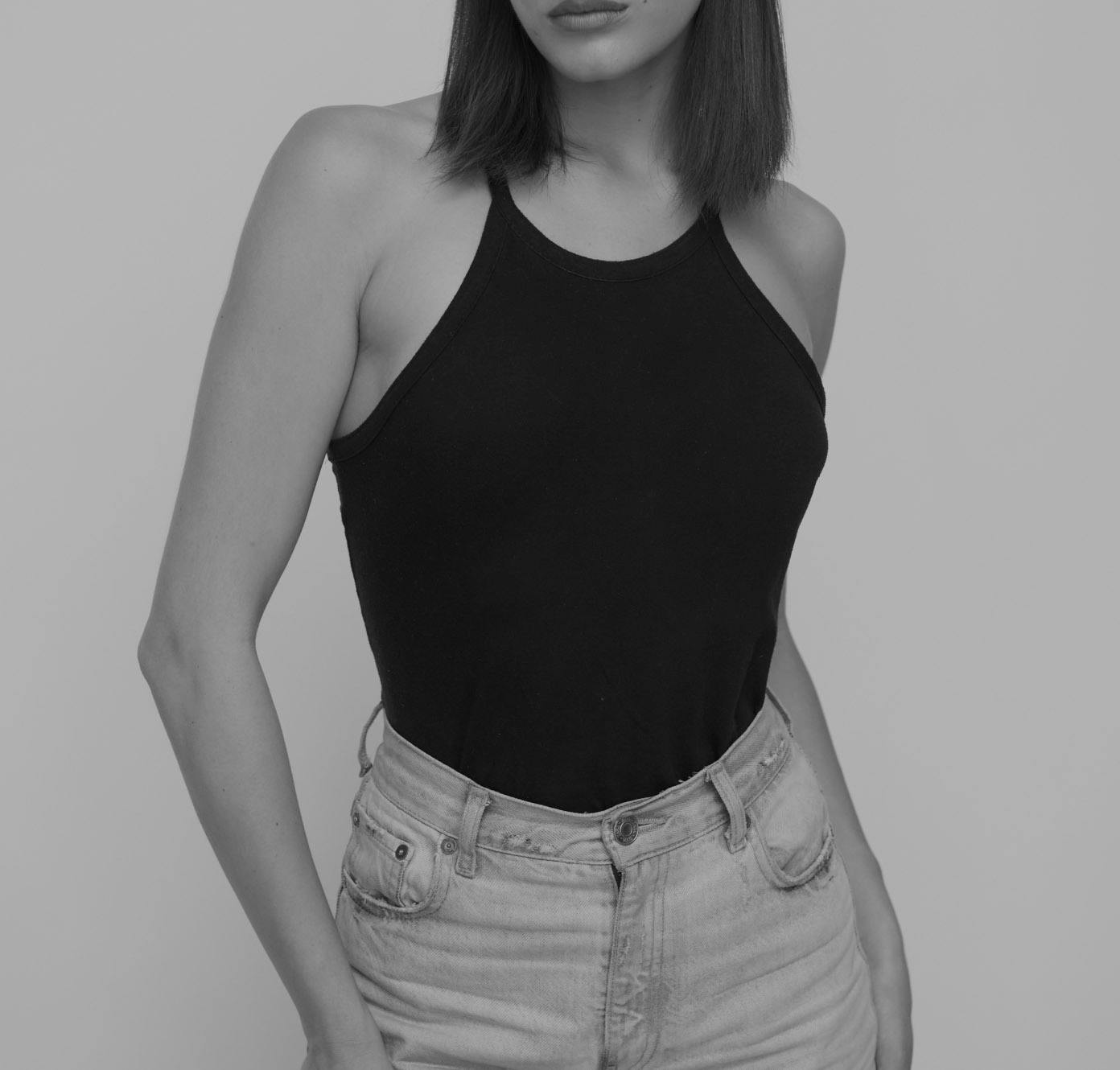 woman in a black tank top and jeans