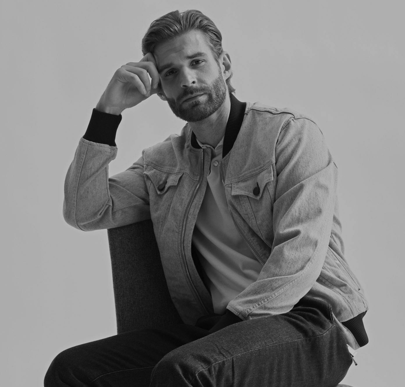 man sitting down with his hand touching the side of his face