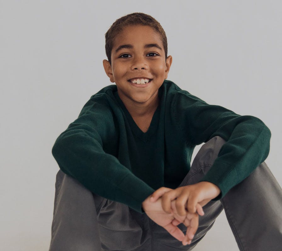 young boy sitting down smiling