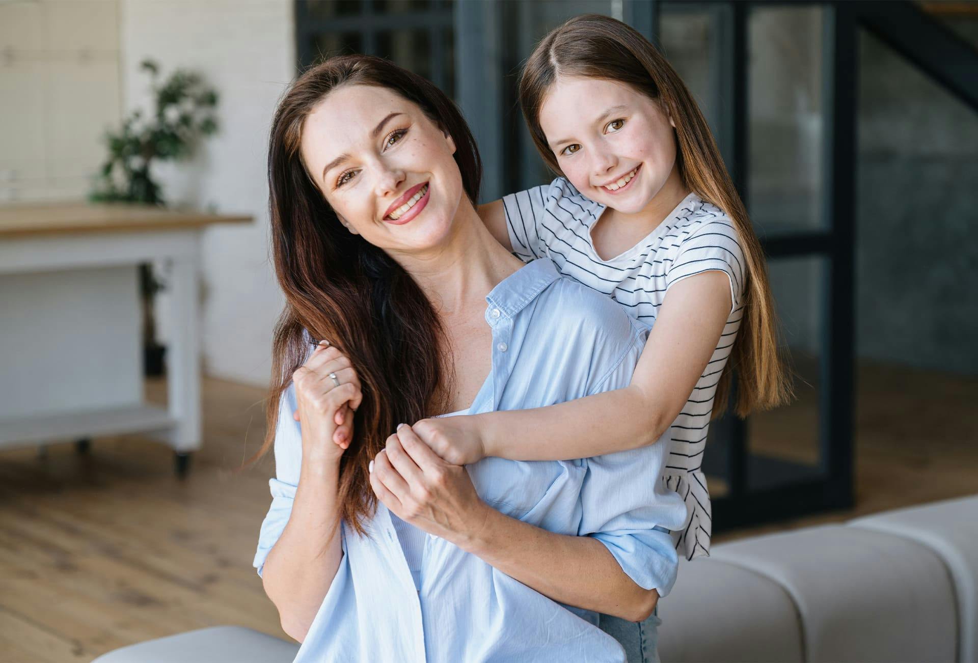 woman with her daughter hugging her from behind