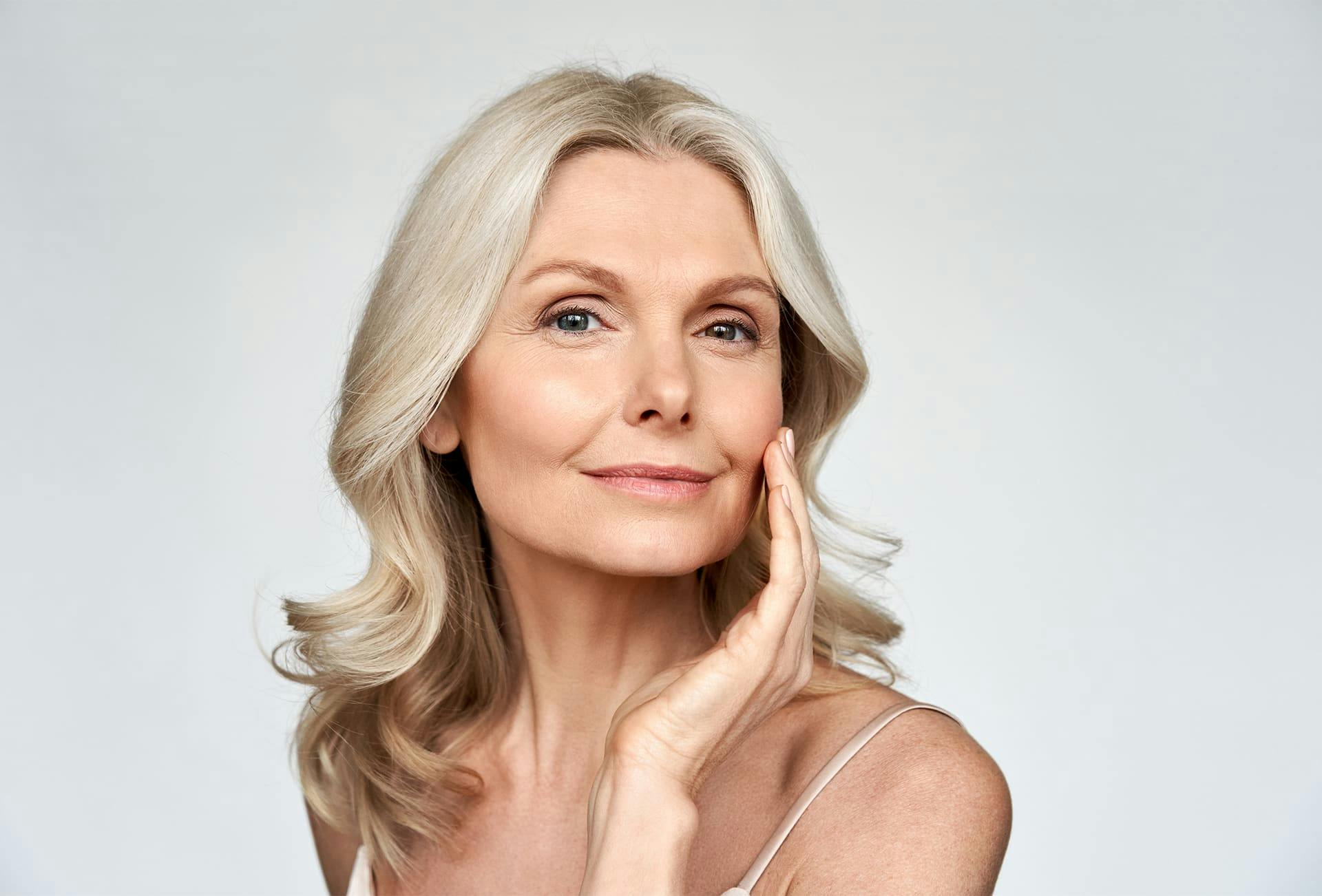 older woman touching her cheek