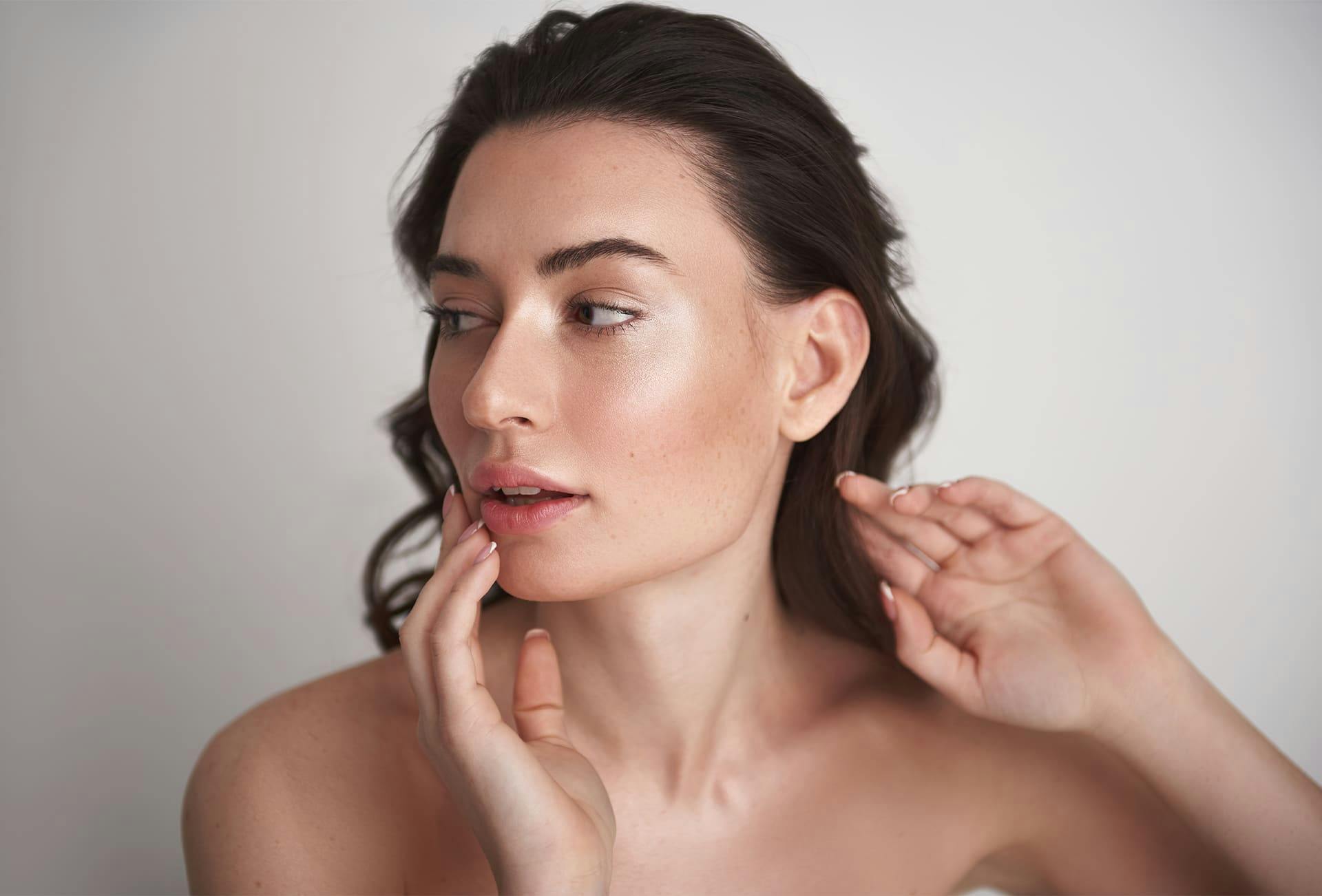 woman looking to the left while her hand touches her chin