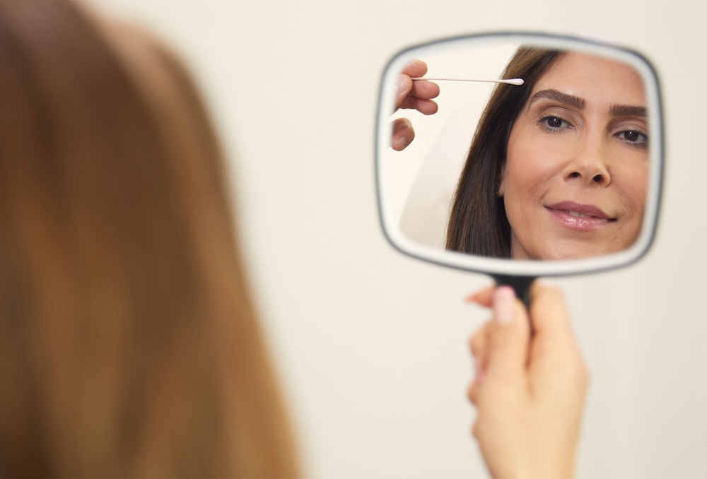 patient looking into handheld mirror