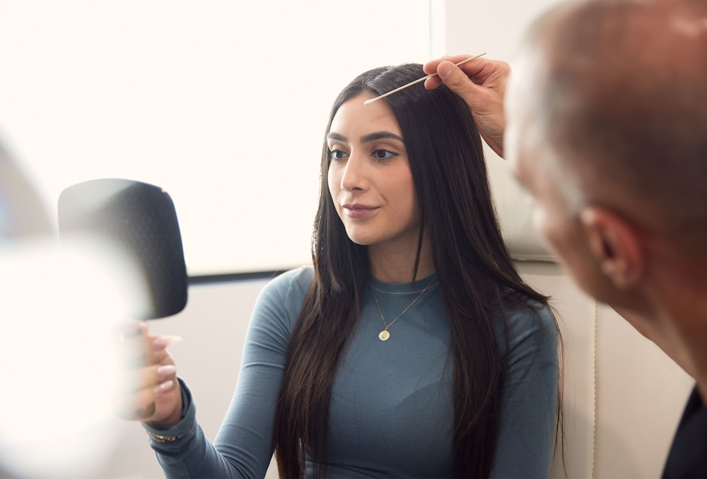 woman looking in a handheld mirror