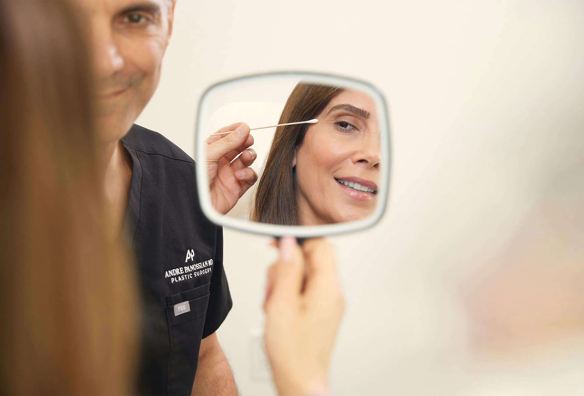 woman looking at herself in a handheld mirror
