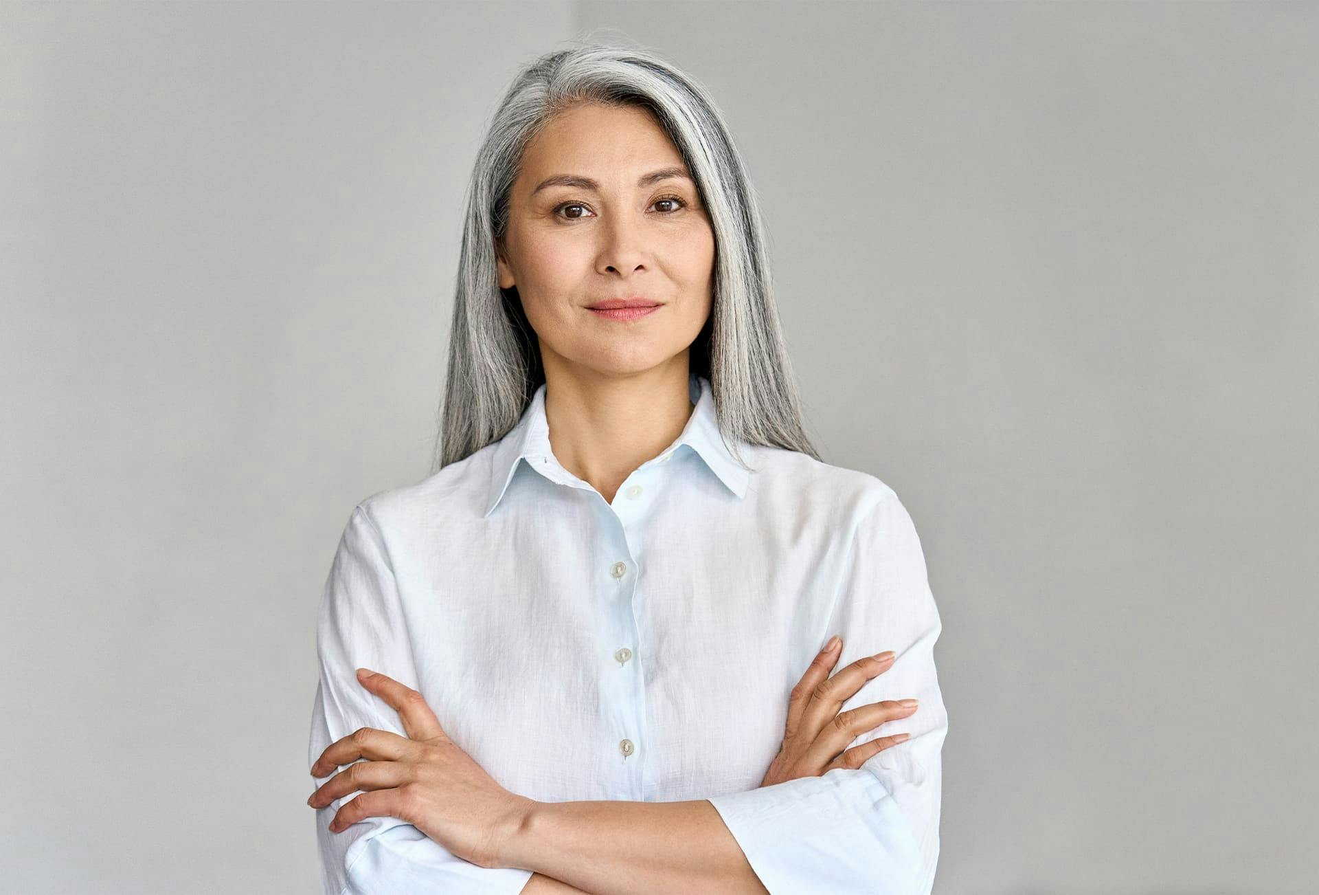 woman with gray long hair crossing her arms