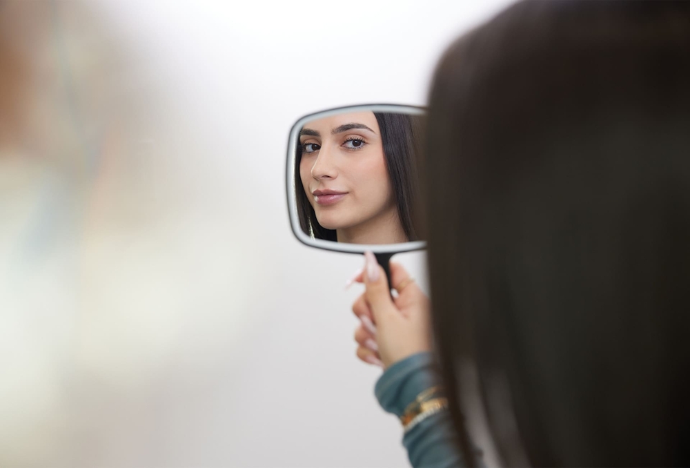 patient holding handheld mirror