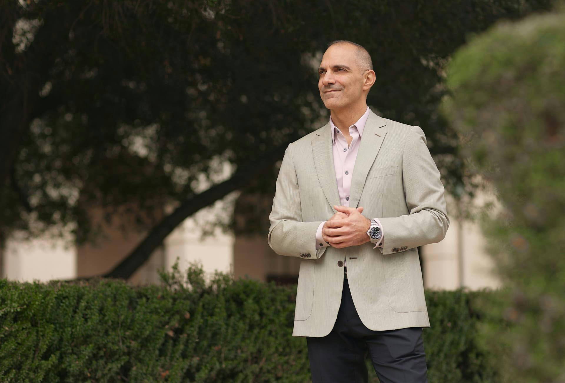 Dr. Panossian clutching his hands in suit