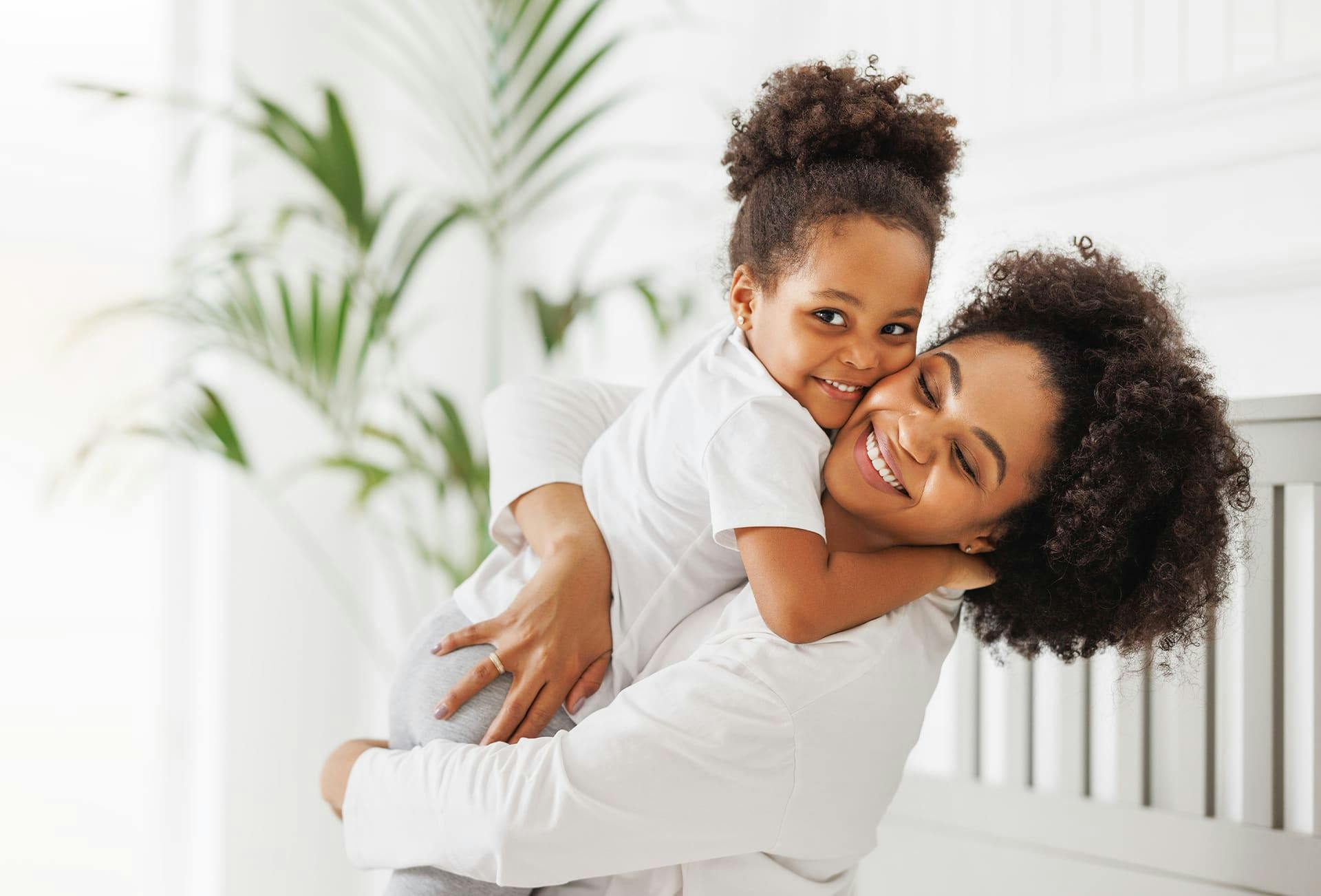 mother holding her daughter and hugging her