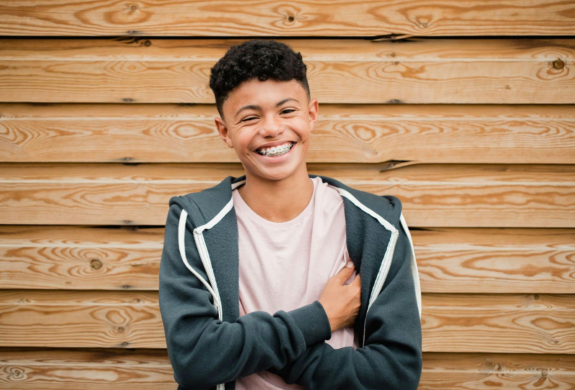 teen boy smiling crossing his arms