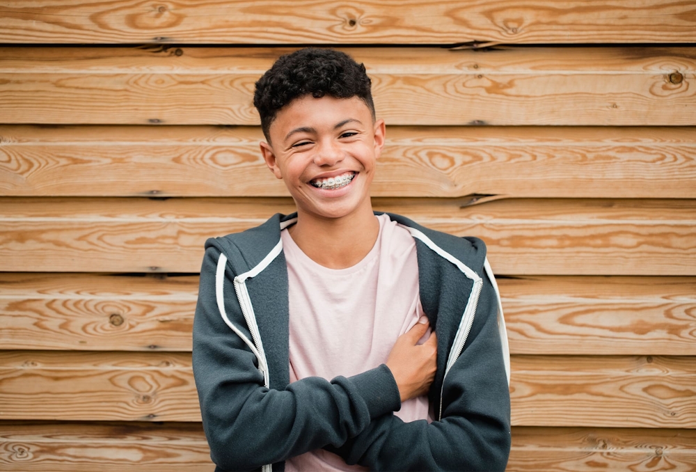 teen boy smiling crossing his arms