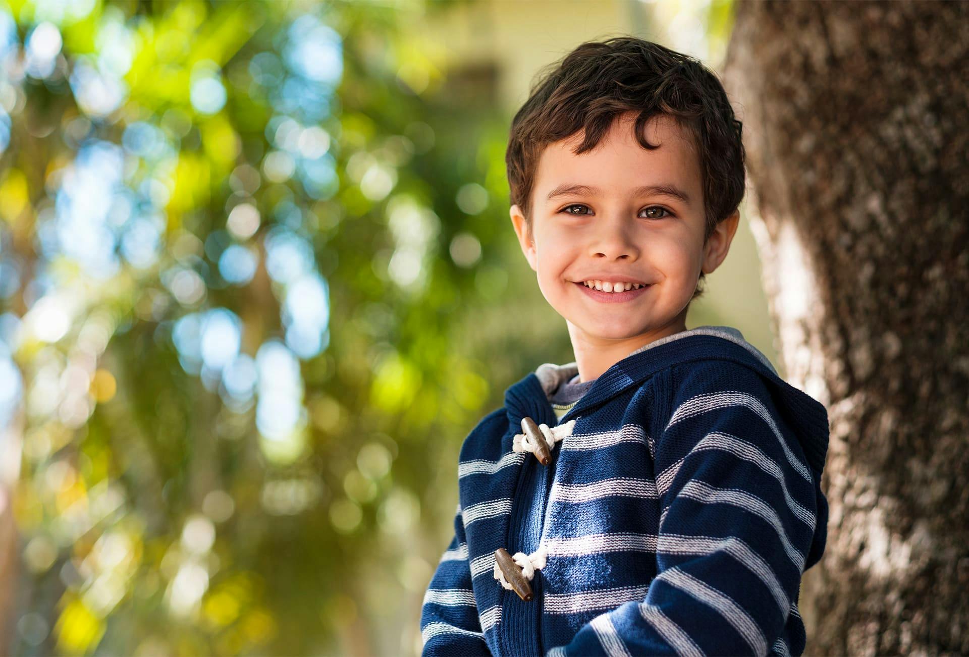 little boy in tree smiling