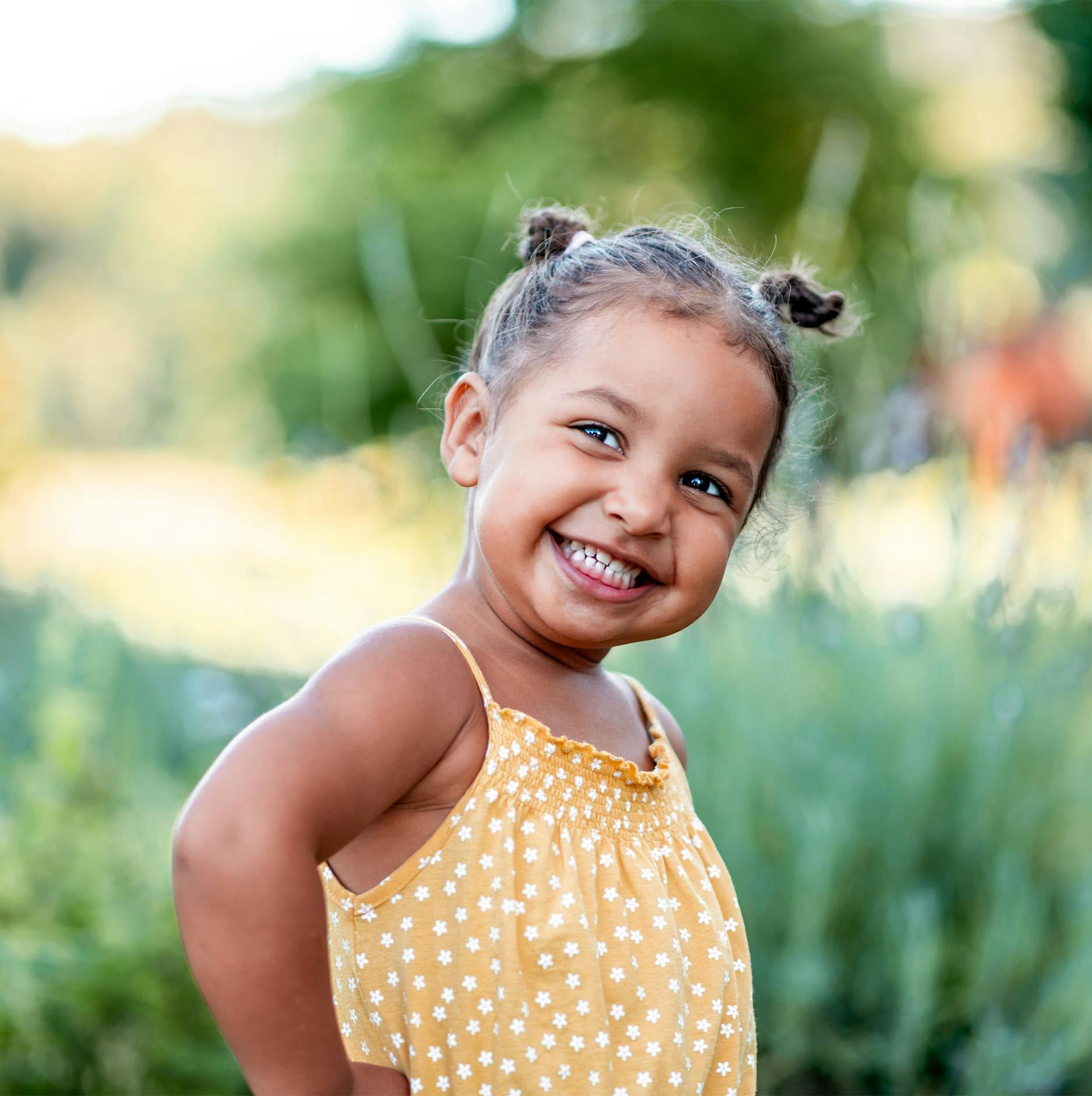 little girl smiling with hands on hips