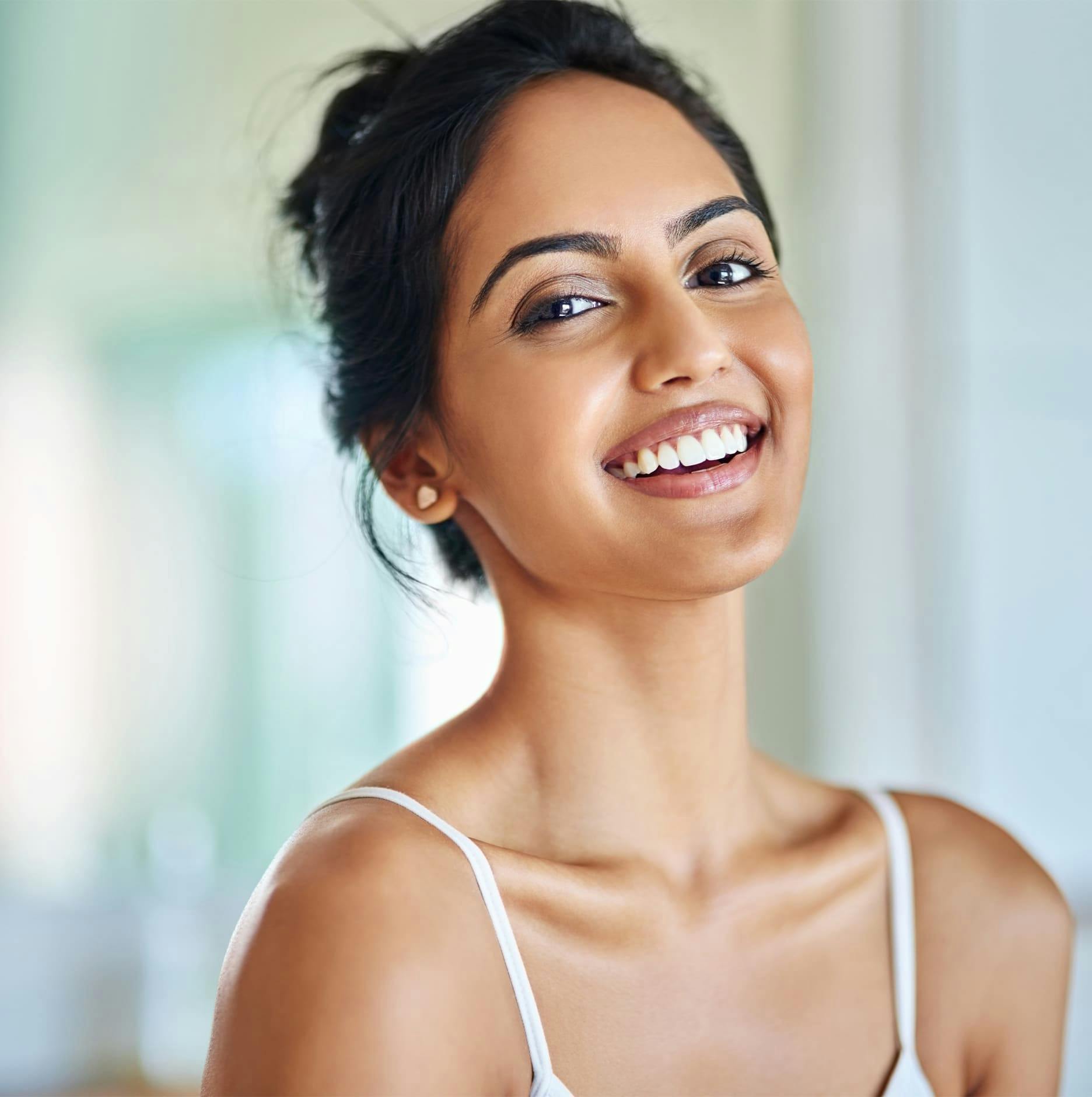 woman with hair in bun smiling forward