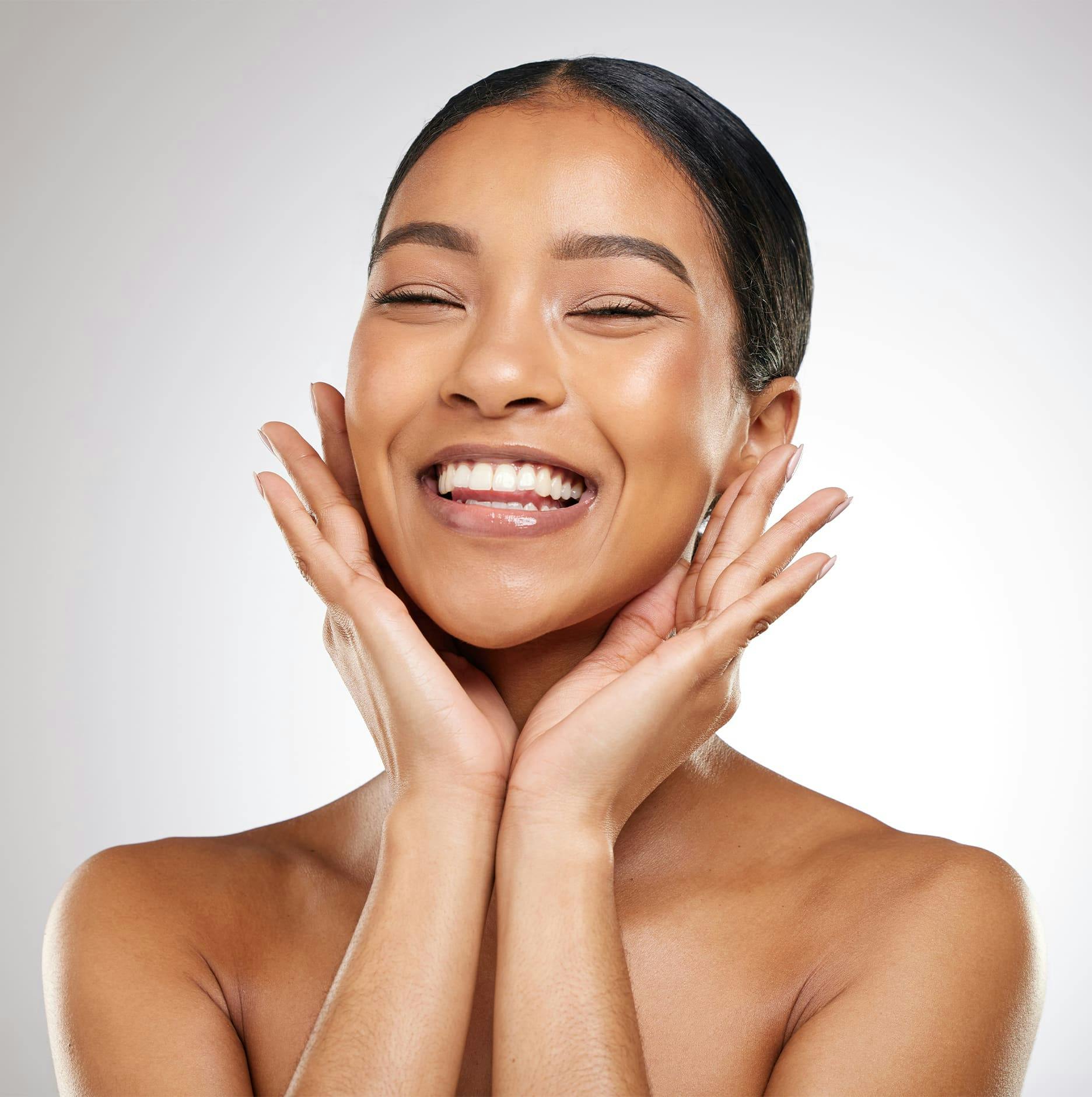 woman touching her jaw and smiling