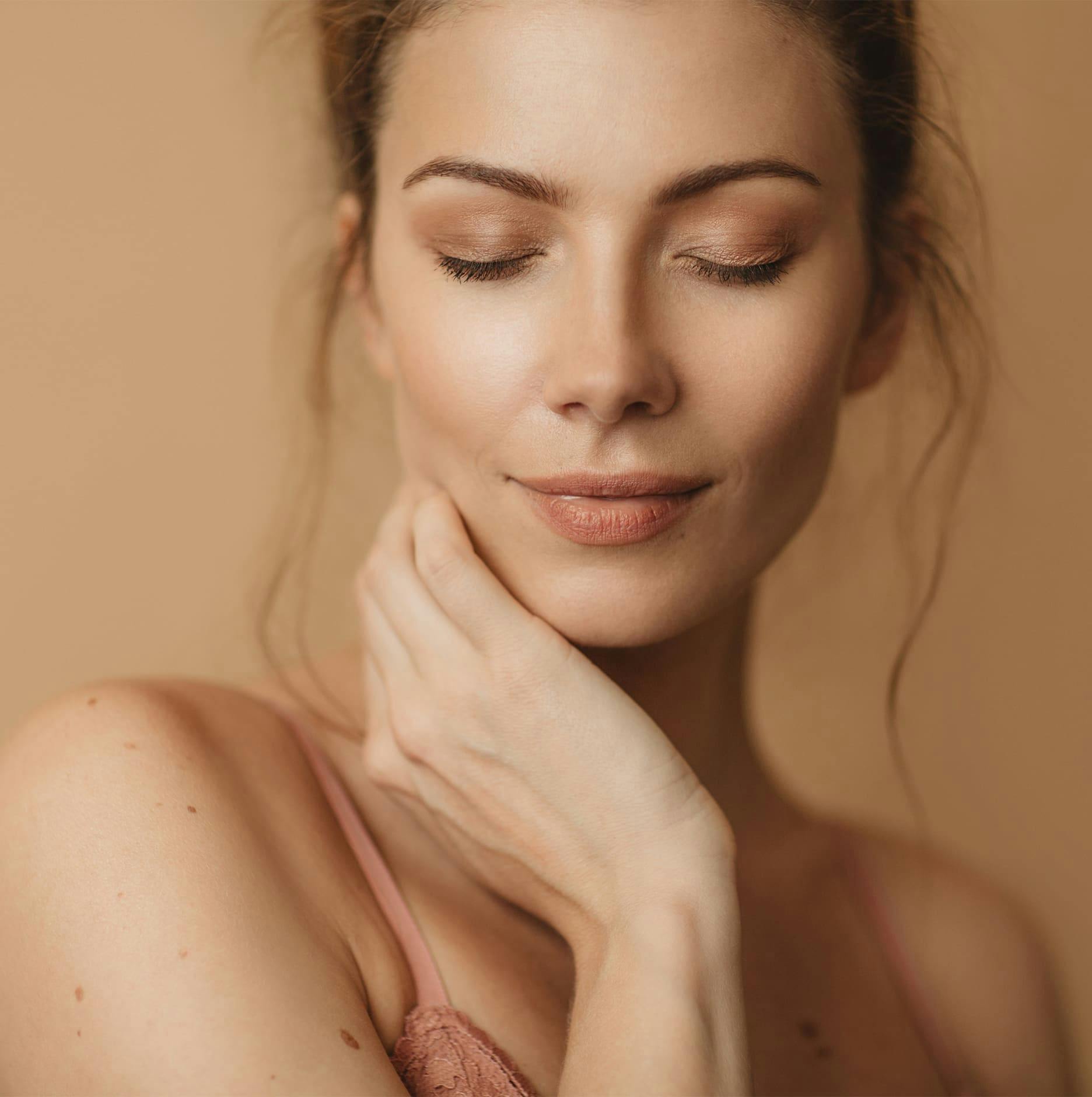 woman closing her eyes with hand on jaw