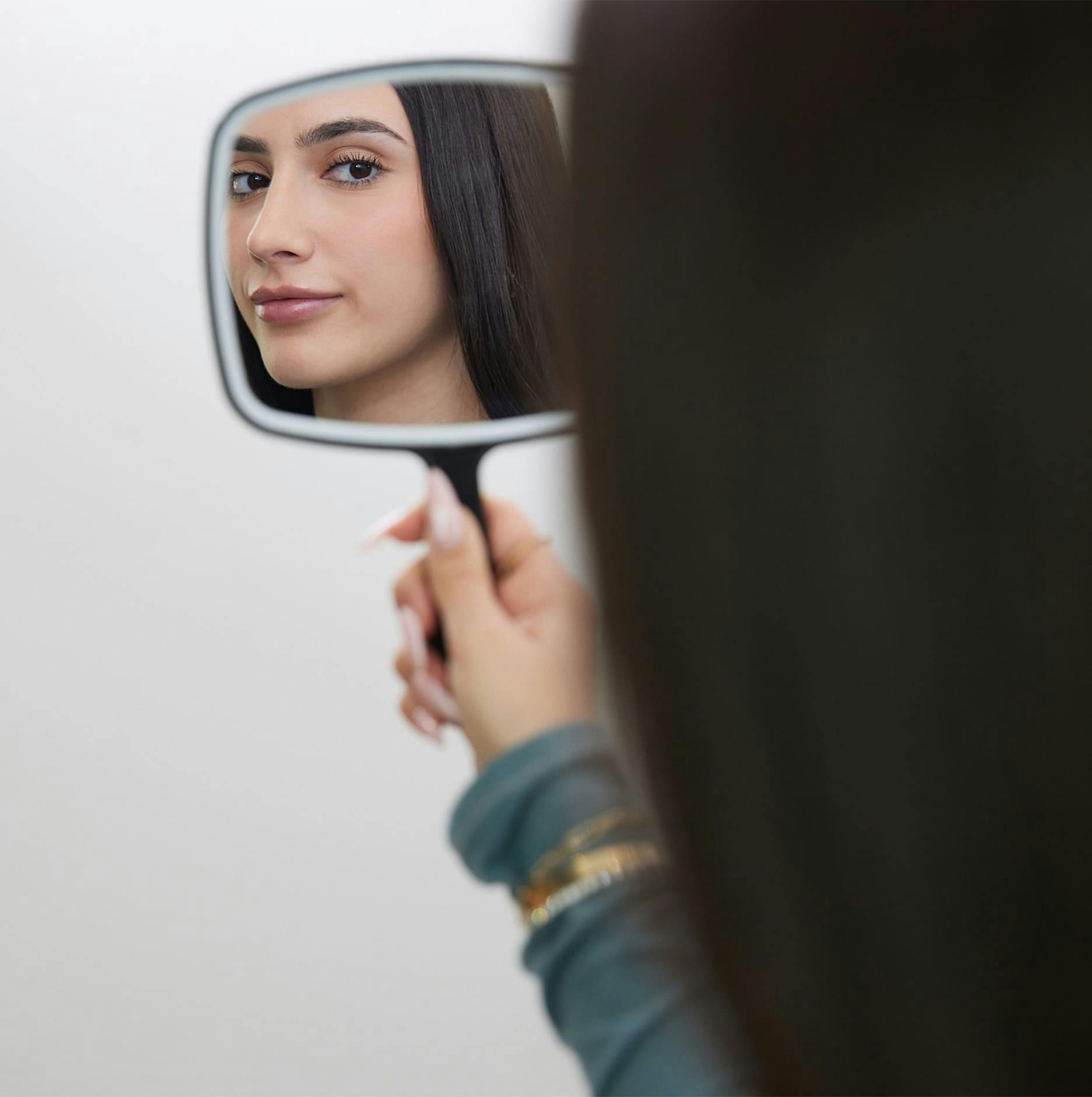 patient looking into handheld mirror