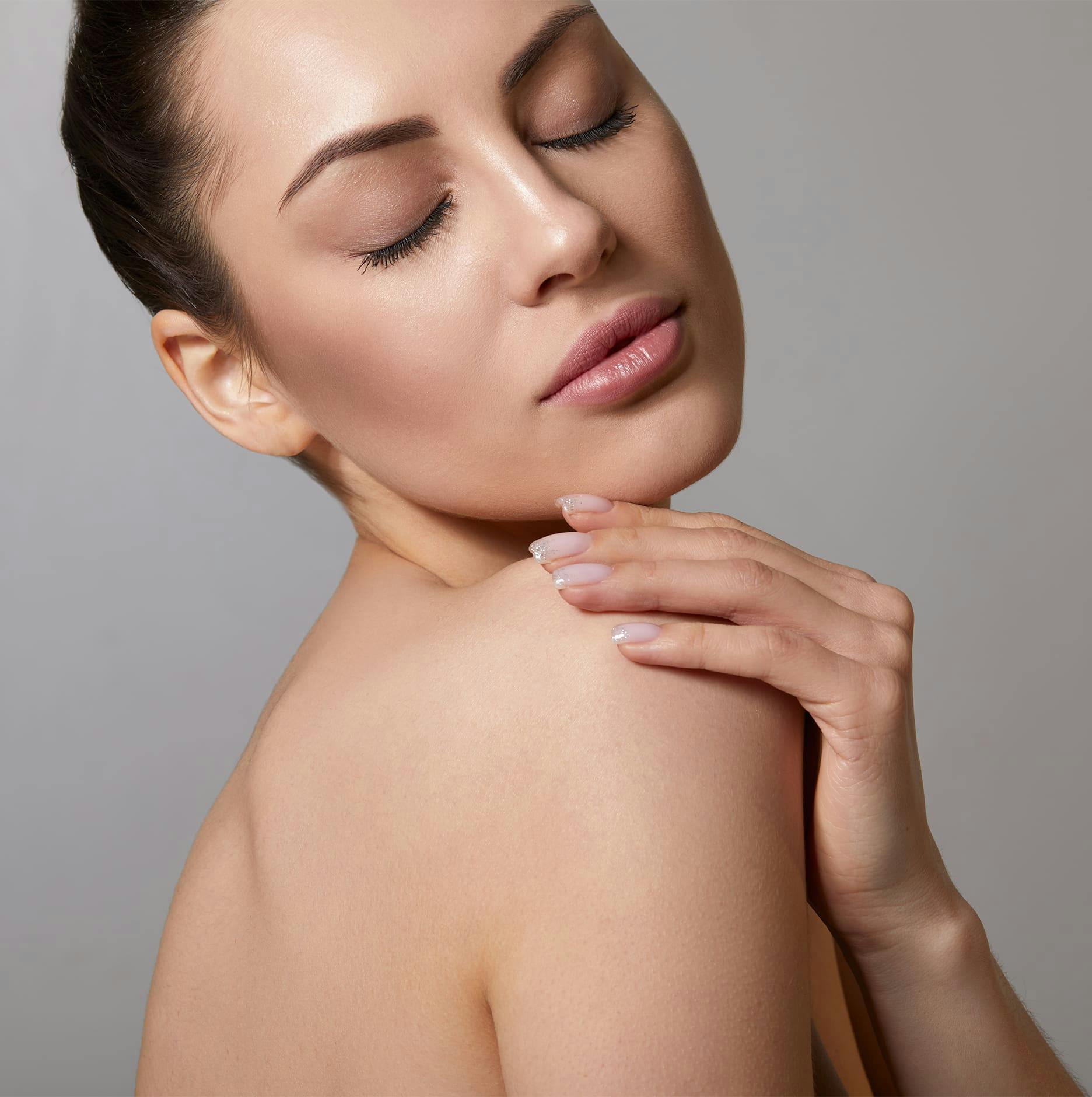 woman looking over shoulder and touching shoulder with her hand