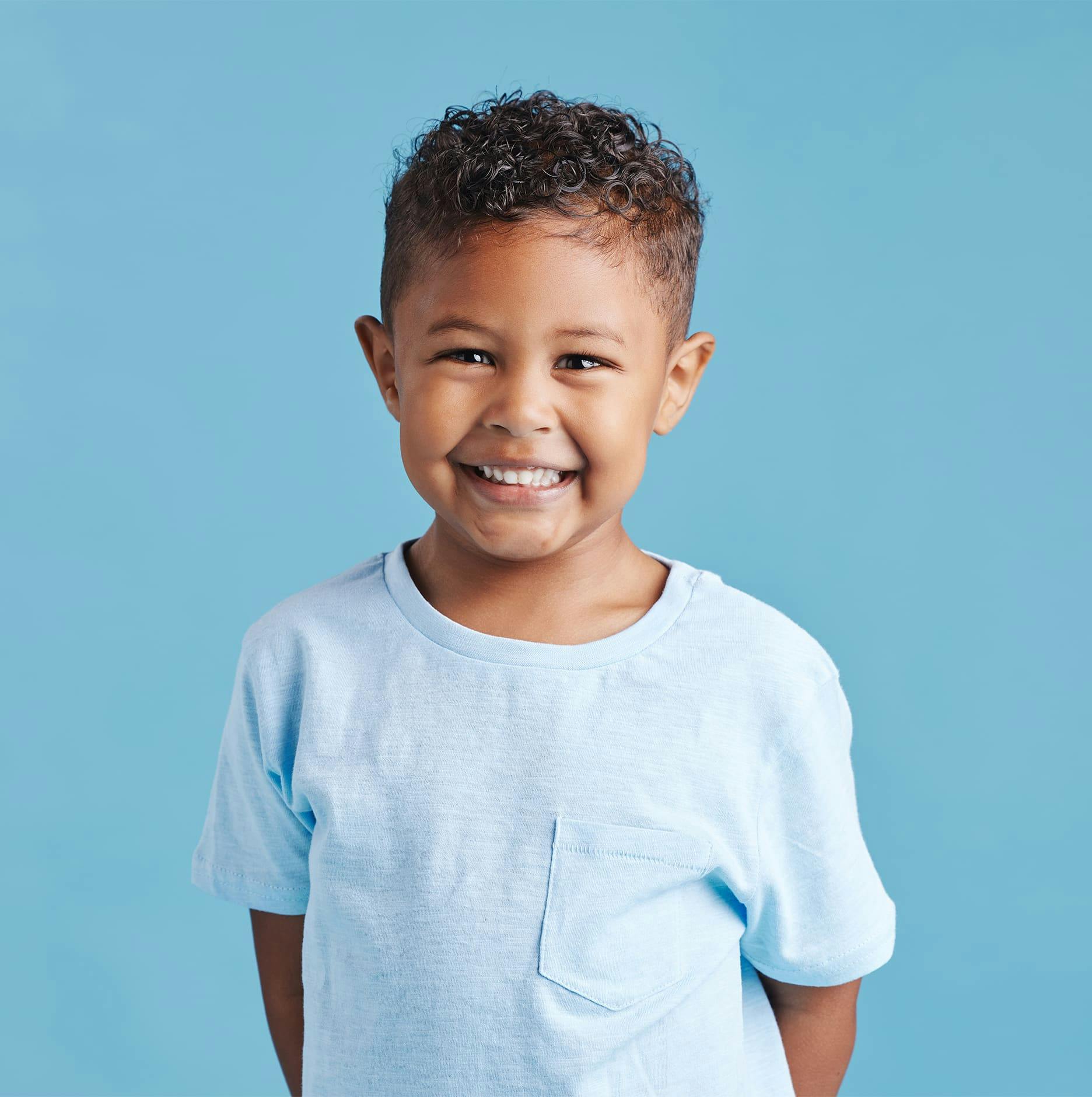 little boy in blue shirt with short curly hair