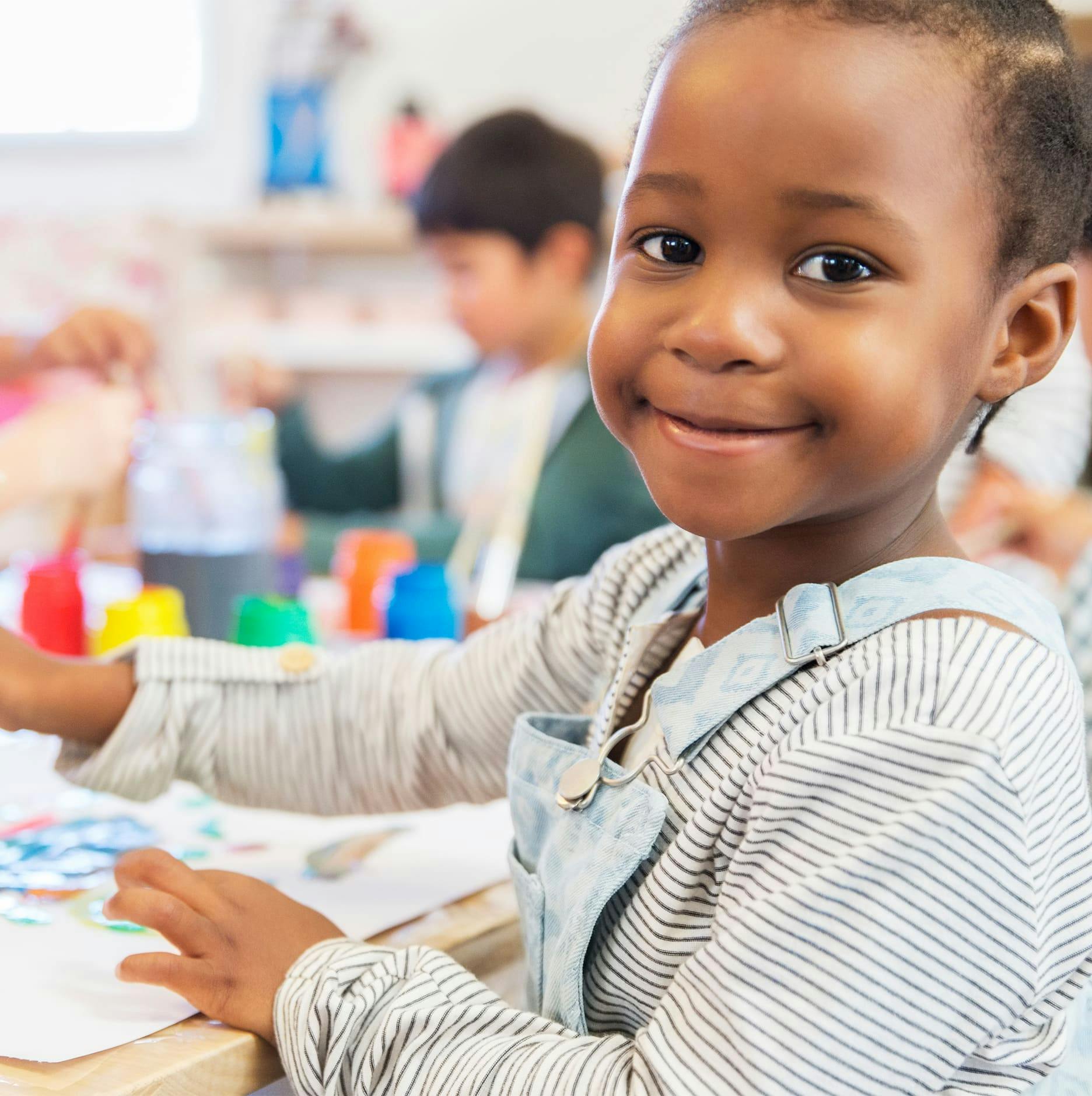 little girl doing art in school