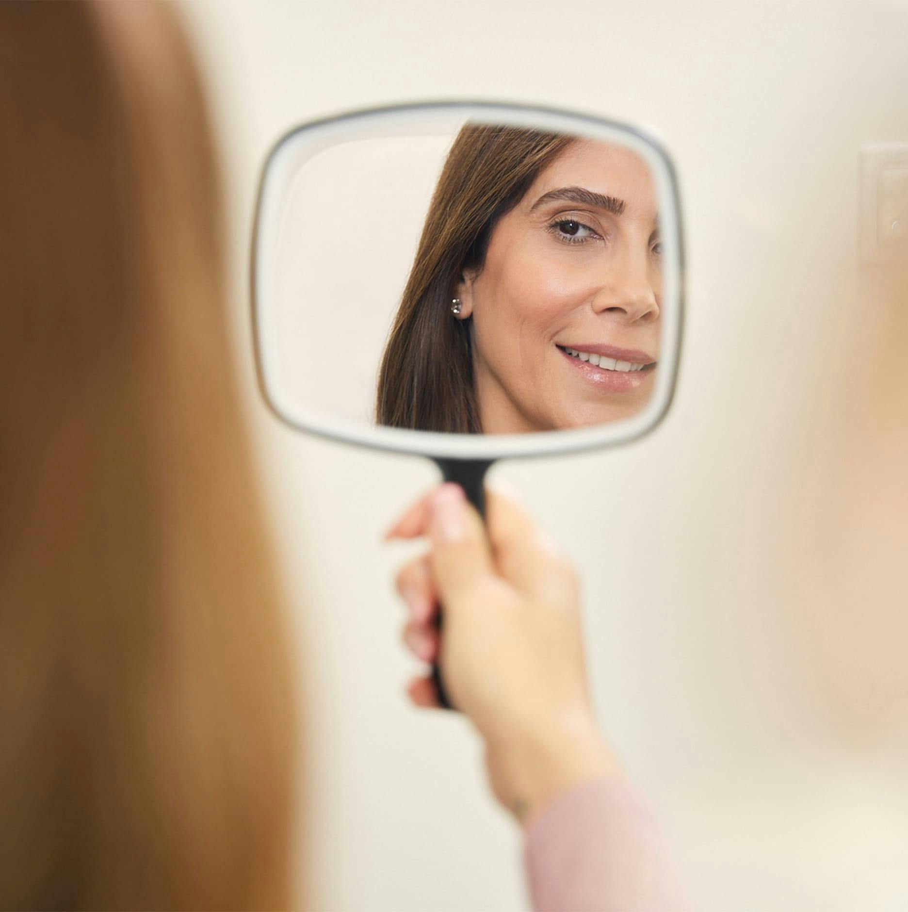 patient looking into handheld mirror