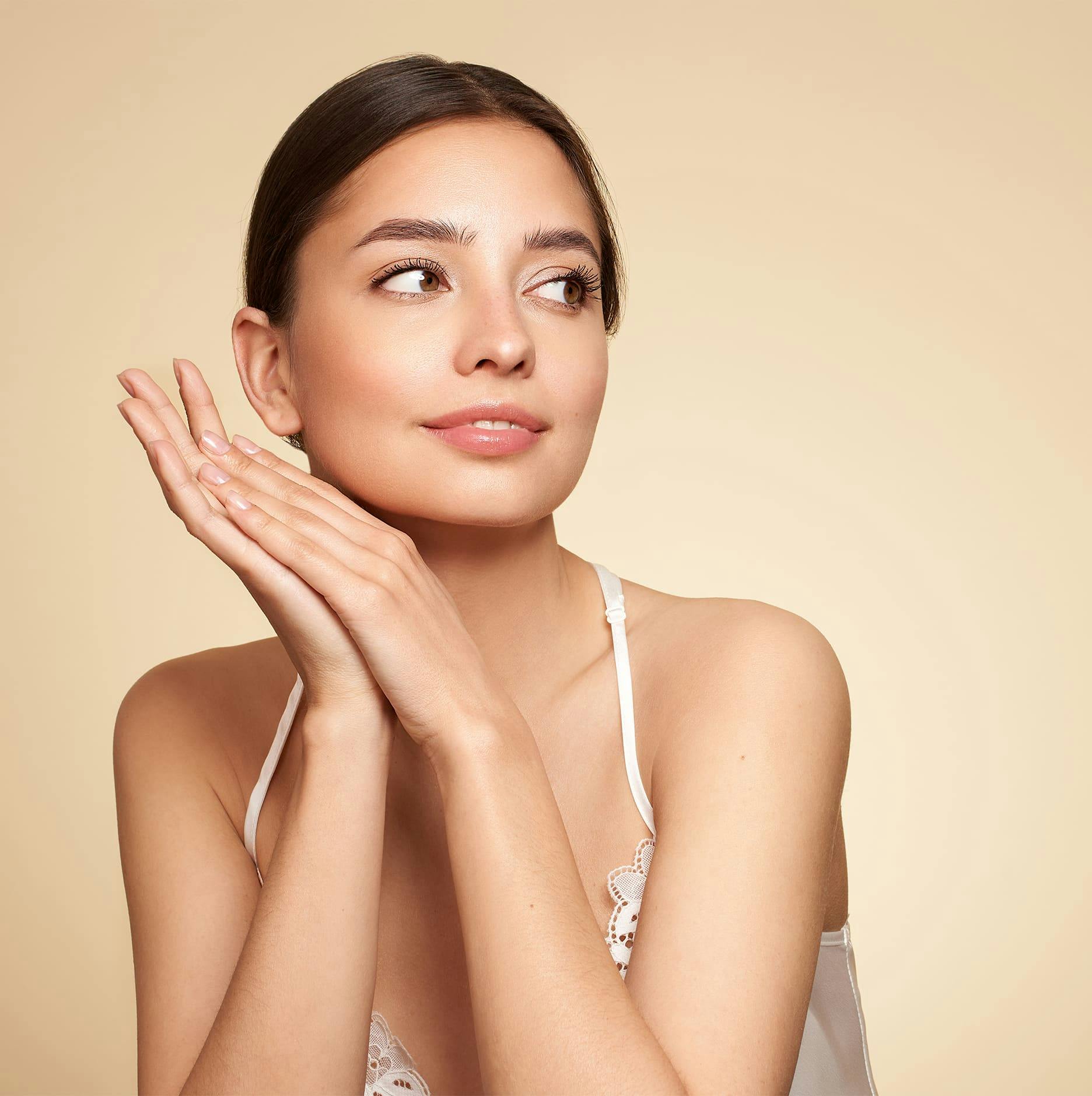 woman looking right with hands touching eachother