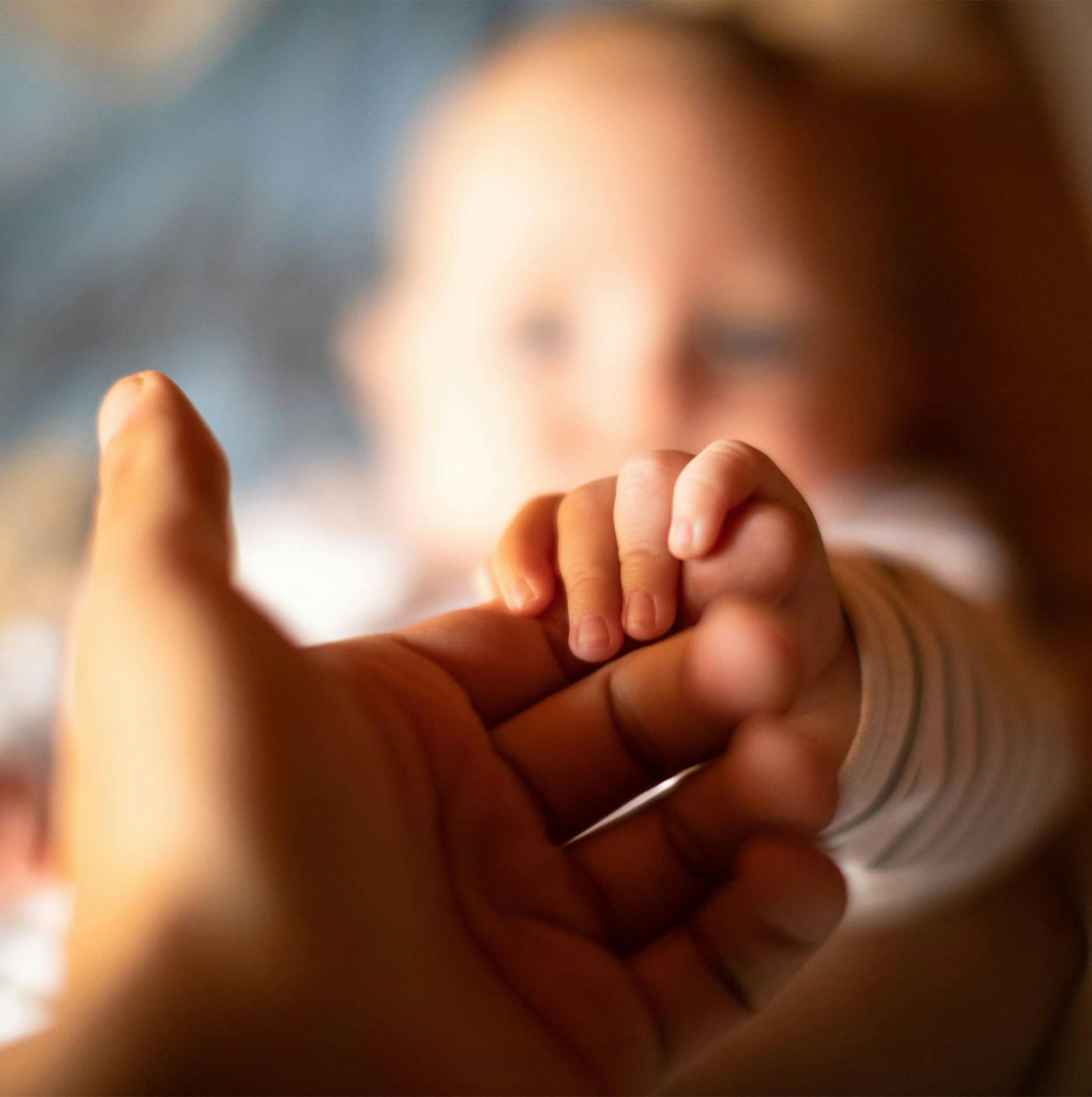 child grabbing parent's finger