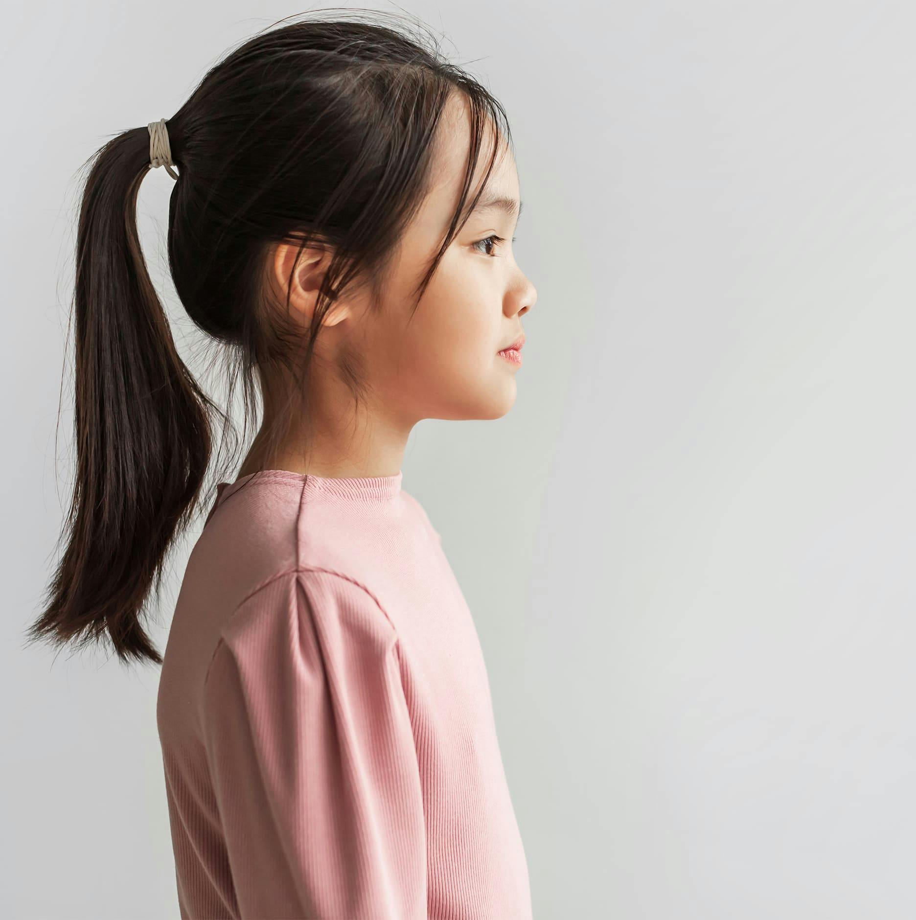 side angle of young girl with a ponytail