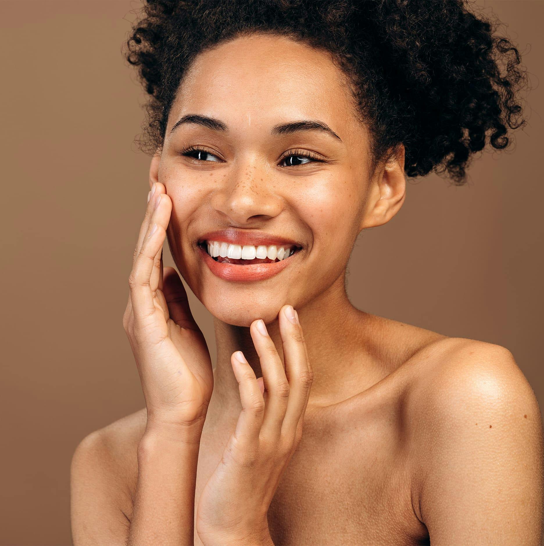 woman with curly hair smiling looking left