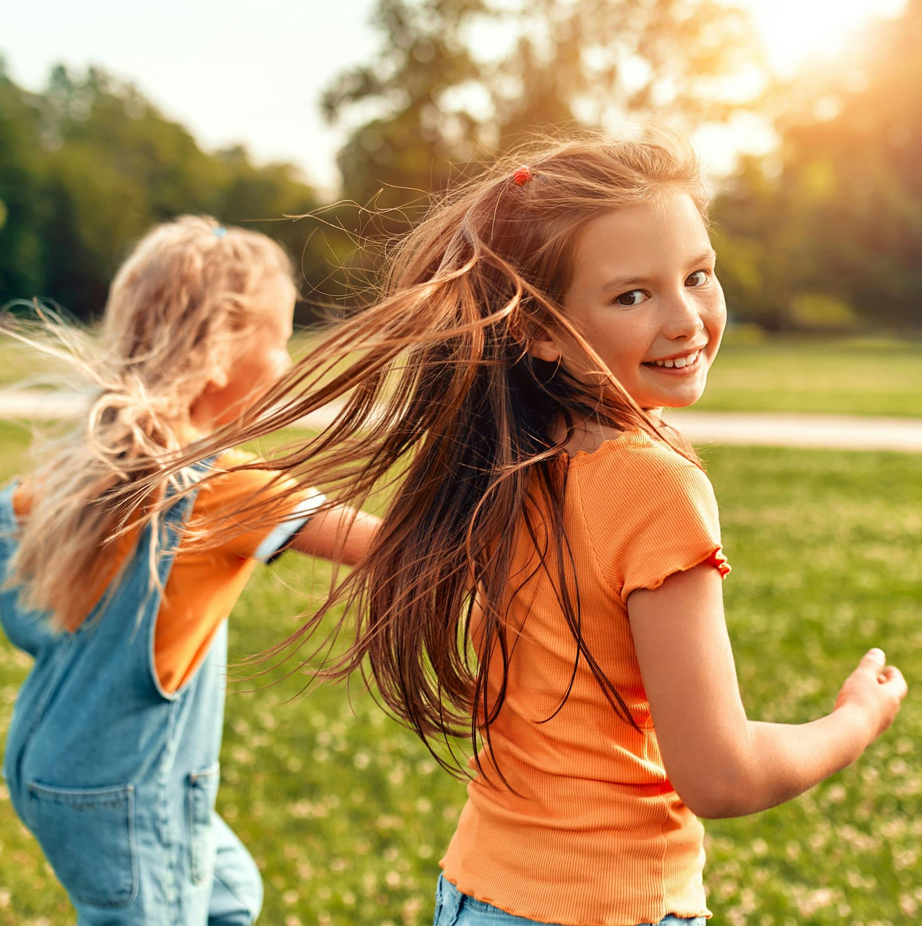 2 little girls running in field