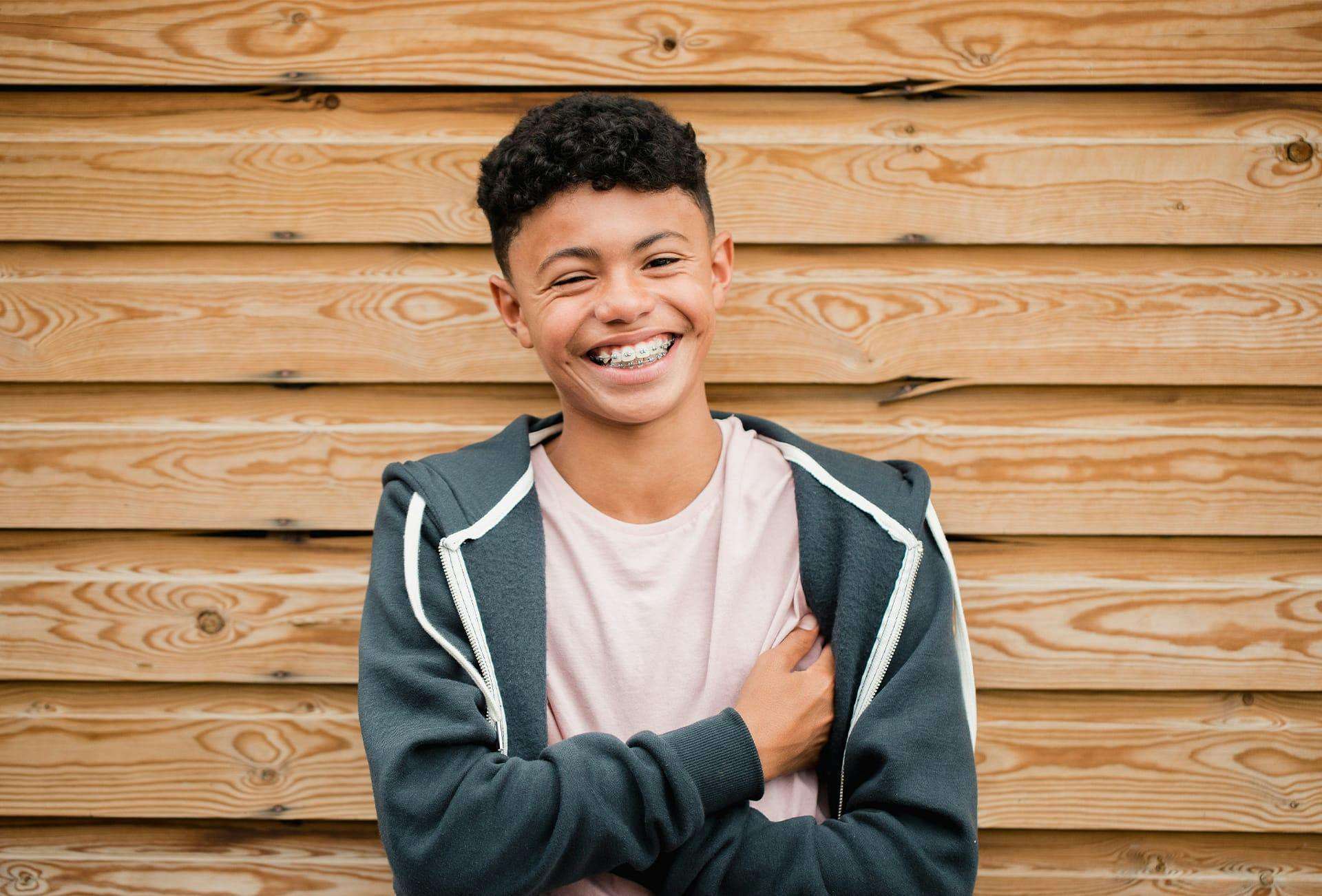 man with hands in his pockets smiling