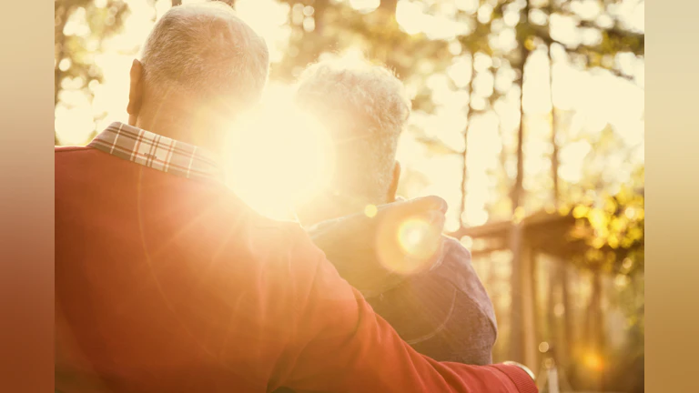 Two people facing the sunset