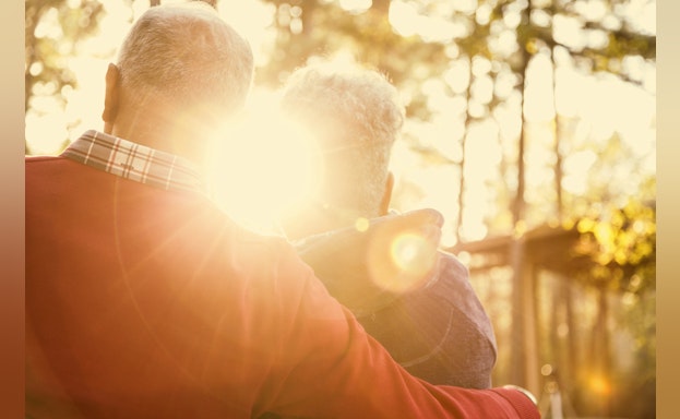 Two people facing the sunset