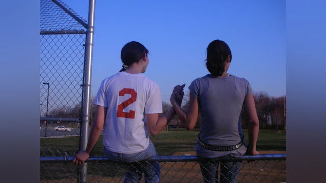 Two girls on a baseball field