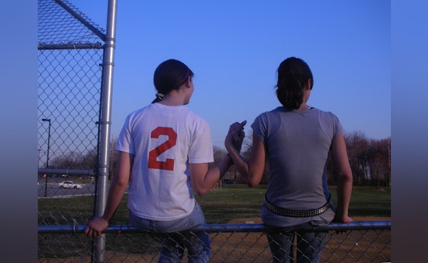 Two girls on a baseball field