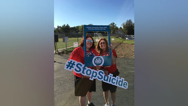 Two women holding signs