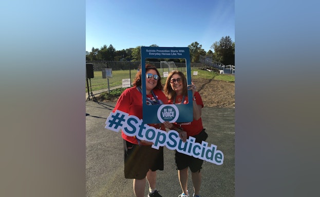 Two women holding signs