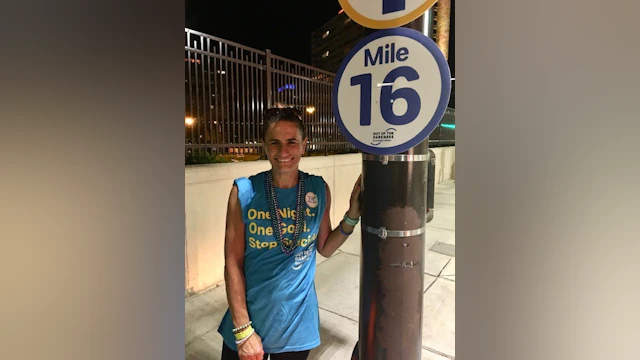 Woman standing in front of sign at walk