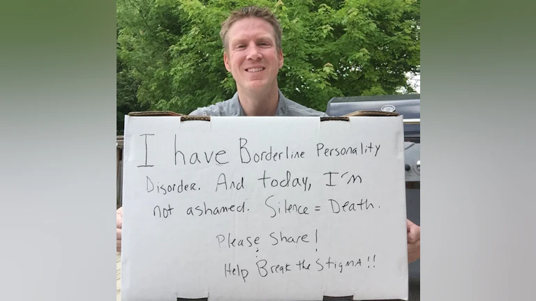 Man holding handwritten sign