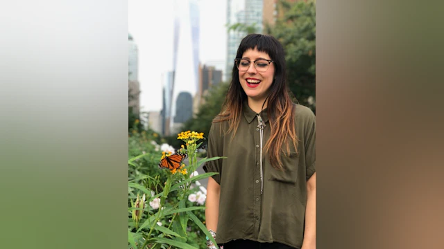 Woman smiling in front of flowers