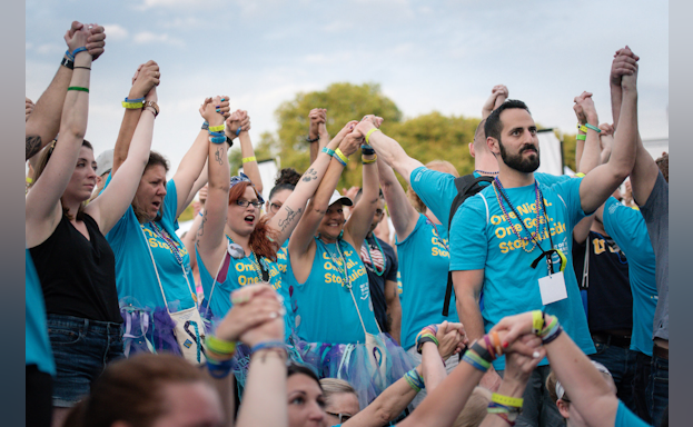 Participants raise their arms together at the Overnight
