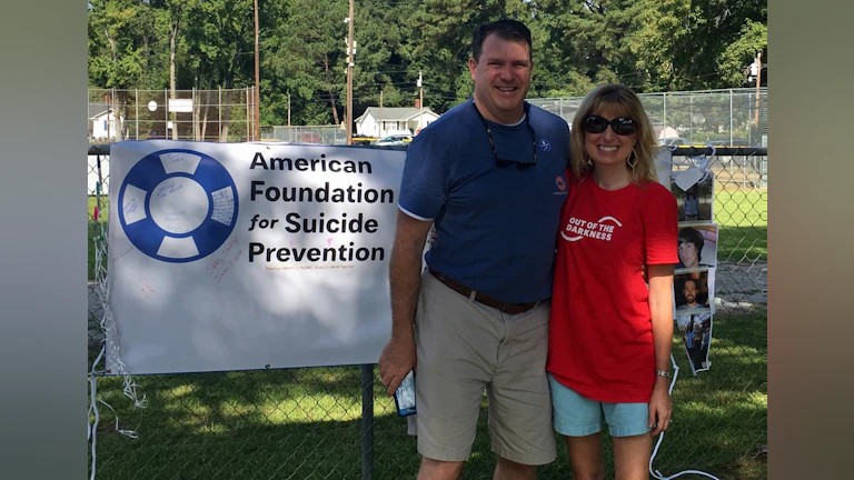 Man and woman in front of AFSP sign