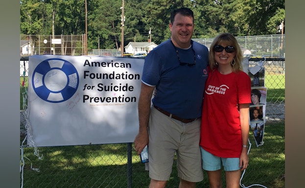 Man and woman in front of AFSP sign