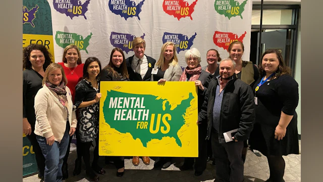 Group holding mental health sign