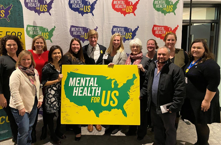 Group holding mental health sign