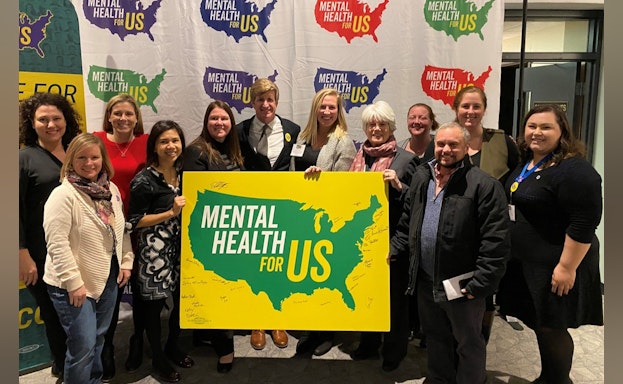 Group holding mental health sign