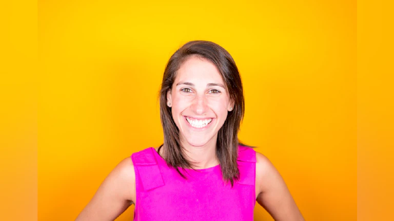 Woman smiling in front of orange background