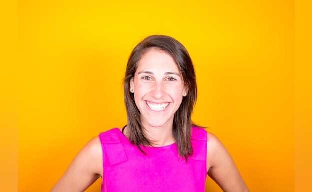 Woman smiling in front of orange background
