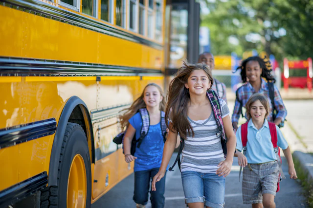 Children running in front of school bus